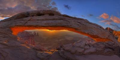 Sonnenaufgang unter dem Mesa Arch mit teilweise verdeckter Sonne<br/>Quelle: snowpeak auf Flickr